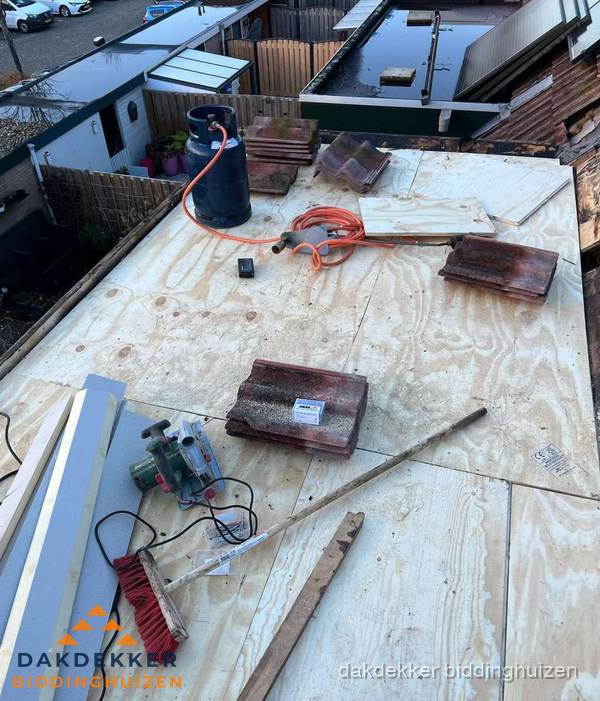 Dakreparatie werkzaamheden op plat dak met gereedschap in Biddinghuizen Dakreparatie werkzaamheden op plat dak met gereedschap in Biddinghuizen